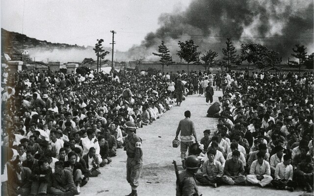 &#10102; 여수 진압 직후 여수서국민학교에서 진행된 혐의자 선별 장면이다. 뒤쪽에 연기가 치솟고 왼쪽에 전봇대와 나무 한그루가 보인다. 시민들이 양쪽으로 나뉘어있다. 왼쪽 사람과 오른쪽 사람의 운명은 여기에서 갈렸다. 이경모 촬영, 1948년 10월. 이경모