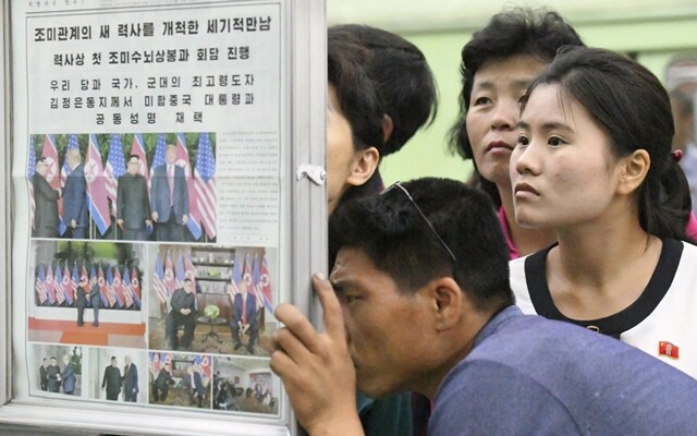 6월13일 평양의 한 지하철 역에서 북한 주민들이 북-미 정상회담 관련 보도가 실린 <노동신문>을 읽고 있다. 연합뉴스