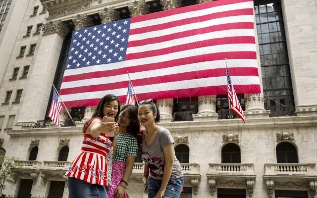 경제성장으로 중산층 인구가 늘면서 외국을 찾는 중국 관광객도 기하급수적으로 늘고 있다. 2017년 8월21일 중국 관광객들이 미국 뉴욕의 증권거래소 앞에서 기념사진을 찍고 있다. REUTERS 연합뉴스