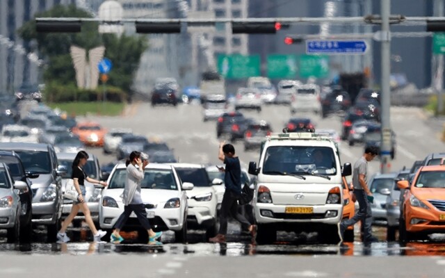 폭염 경보가 내린 7월31일 시민들이 서울 여의도의 한 횡단보도를 건너고 있다.  류우종 기자