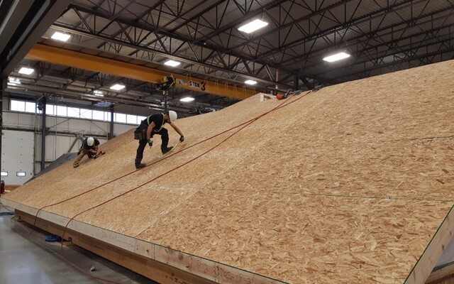 캐나다 에드먼턴의 에이시큐건축 공장에서 숙련공들이 목조주택의 지붕을 만들고 있다.