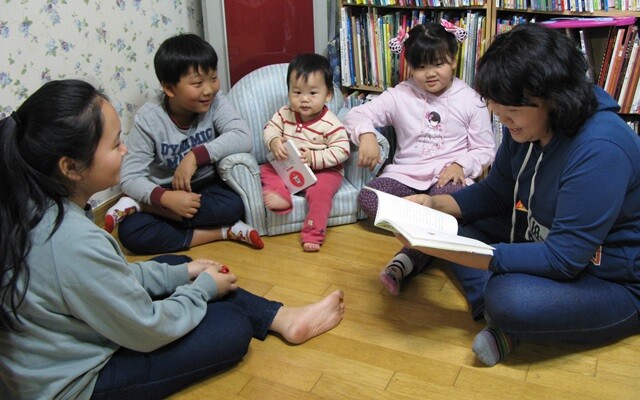 엄마가 아이들에게 책을 읽어주고 있다. 한겨레