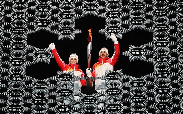 지난 4일 열린 베이징겨울올림픽 개막식에서 위구르인 스키 선수 디니거얼 이라무장(왼쪽)이 성화 최종 주자로 등장했다. 베이징/AFP 연합뉴스
