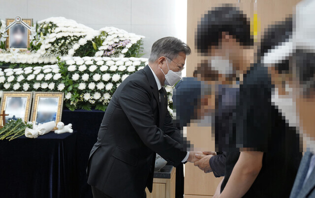 South Korean President Moon Jae-in, during his visit to the memorial for the Air Force master sergeant who died by suicide after being sexually assaulted by a fellow service member, consoles the victim’s family members on Sunday. (Yonhap News)