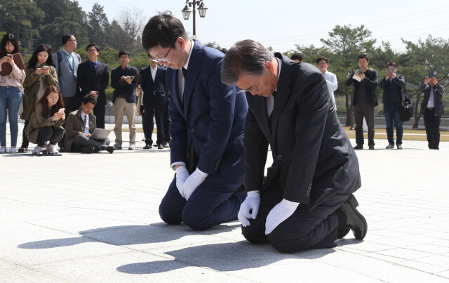 Former Minjoo Party of Korea leader Moon Jae-in kneels as he pays respects at the Gwangju May 18 National Cemetery with Kim Hong-gul