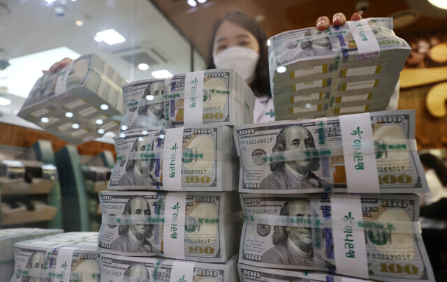 An employee at a bank in Seoul stacks $100 bills. (Yonhap)