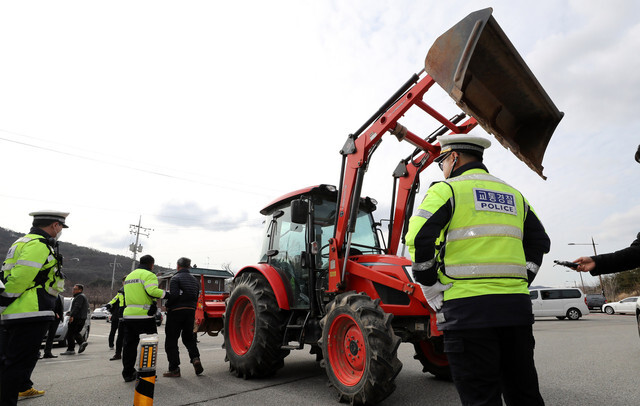 <b>Residents of Asan, South Chungcheong Province, protest a government decision to quarantine South Koreans repatriated from Wuhan, China, by blocking a police training center with tractors on Jan. 29. </b>
