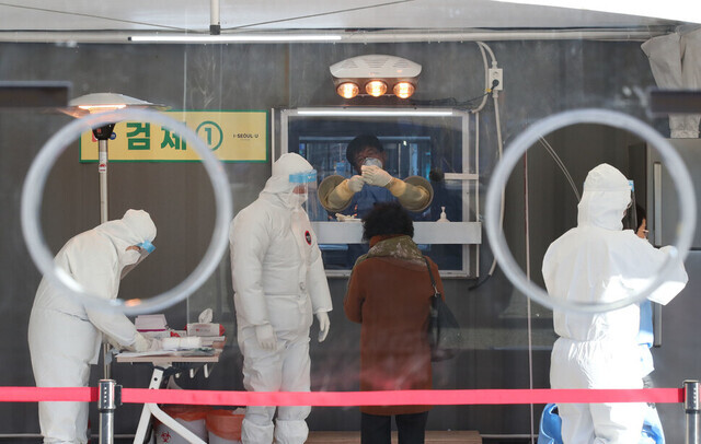 In this undated photo, medical workers can be seen preparing to administer COVID-19 tests at a temporary screening station set up in Seoul Plaza in the capital’s Jung District. (Baek So-ah/The Hankyoreh)