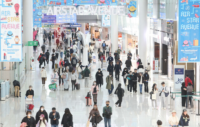 Travelers walk past duty free stores at Incheon International Airport. (Yonhap)