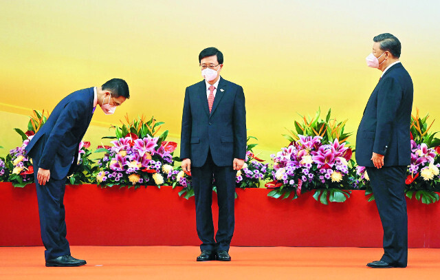 Chinese President Xi Jinping (right) stands alongside John Lee Ka-chiu (center) at an event celebrating the latter’s appointment as chief executive of Hong Kong on July 1 in Hong Kong. (AFP/Yonhap)