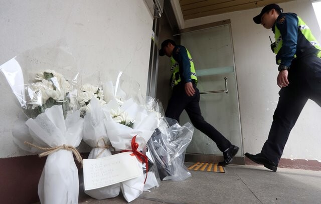 방화 살인 참사가 벌어진 경남 진주의 아파트 출입구에 4월21일 하얀 국화 다발들이 놓여 있다. 연합뉴스