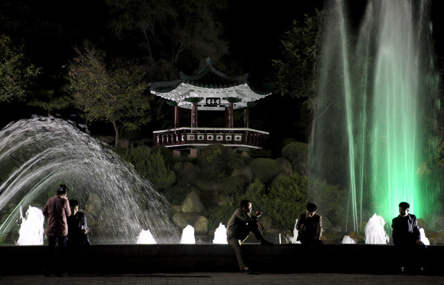 Young Pyongyang residents and couples enjoy a relaxing evening with drinks in front of the Kaeson Youth Park fountain. (provided by Unification TV)