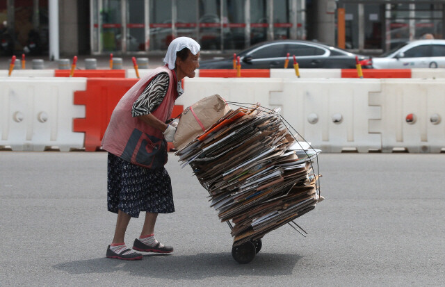 2016년 8월 서울 서부역 도로를 한 할머니가 한낮의 땡볕을 손수건 한장으로 겨우 가린 채 폐지를 고물상으로 가지고 가고 있다. 김봉규 선임기자 bong9@hani.co.kr
