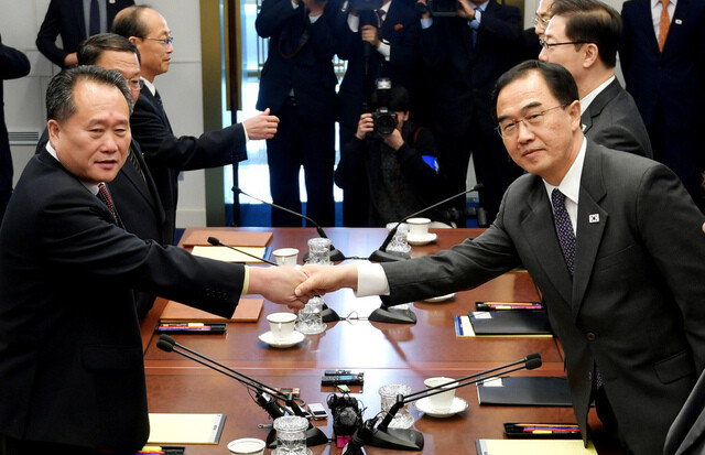 South Korean Minister of Unification Cho Myoung-gyon (right) and North Korean Committee for the Peaceful Reunification of the Fatherland Chairman Ri Son-gwon shake hands before their high-level talks at the House of Peace in the South Korean area of Panmunjom on Oct. 15. (photo pool)