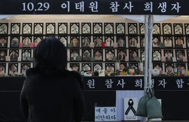 Jo Mi-eun, the mother of Itaewon crowd crush victim Lee Ji-han, gazes at the citizen-erected memorial altar for those killed in the crowd crush as she visits the area on Jan. 1. (Kim Bong-gyu/The Hankyoreh)