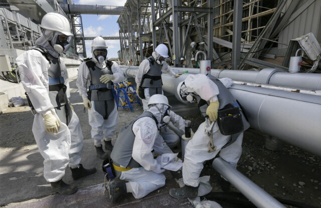 Staff from TEPCO and experts work on a leak of radioactive water from reactor 4 at the nuclear plant in Fukushima