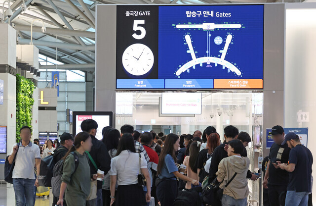 Travelers wait in the security line at Incheon International Airport’s Terminal 1 on Sept. 26, ahead of the Chuseok holiday. (Yonhap)