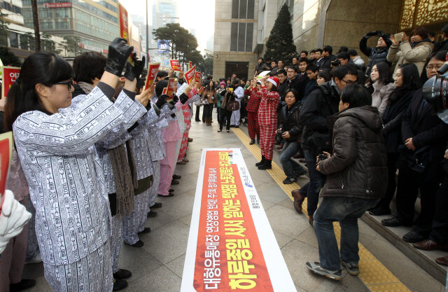 2011년 12월14일 서울 중구 소공동 롯데백화점 앞에서 서비스유통 노동자들이 환자복과 파자마를 입은 채 ‘유통업체 연장 영업 반대’ 등을 요구하는 플래시몹을 하고 있다. 한겨레 김태형 기자