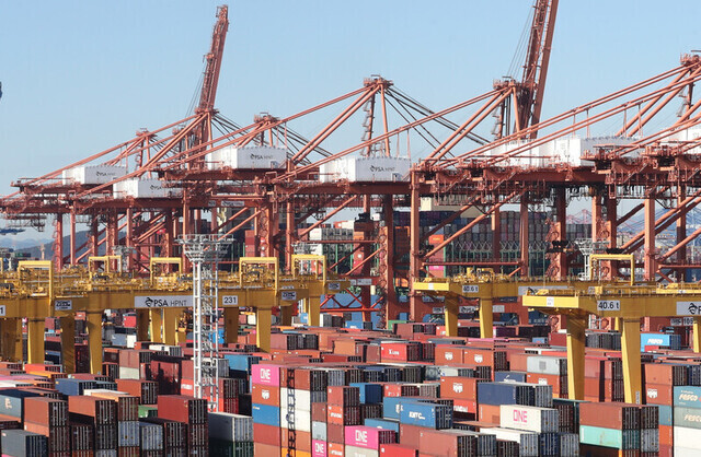 Cranes move freight containers onto ships from Busan Port. (Yonhap)