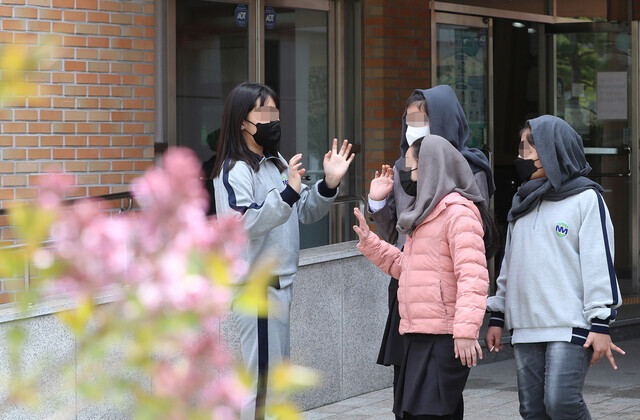 Tamana, Aisha and Zarina say hi to a friend after eating lunch at their school’s cafeteria on April 7. (Shin So-young/The Hankyoreh)