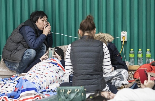 규모 5.4의 지진이 발생하고 하루가 지난 11월 16일 경북 포항시 흥해실내체육관에 대피한 시민들이 가족의 안부를 묻는 전화를 하고 있다. 연합뉴스