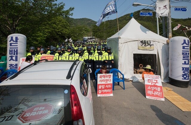 사드기지로 향하는 유일한 통로인 진밭교를 경찰이 막아서자, 평화지킴이(시민단체 활동가)들이 손팻말을 들고 항의하고 있다.