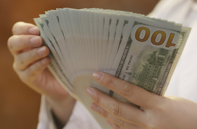 A worker at a KEB Hana Bank in downtown Seoul organizes dollar bills on May 12. (Yonhap News)