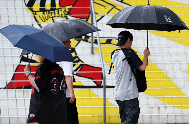 지난 14일 오후 광주 북구 임동에서 시민들이 내리는 가을비에 우산을 쓰고 걸어가고 있다. 연합뉴스