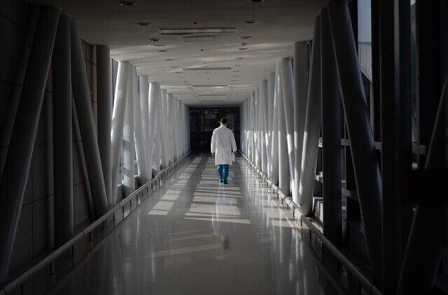 A doctor walks down a hallway alone in a major Seoul hospital on March 4, 2024, amid a mass walkout by interns and residents. (Yonhap)