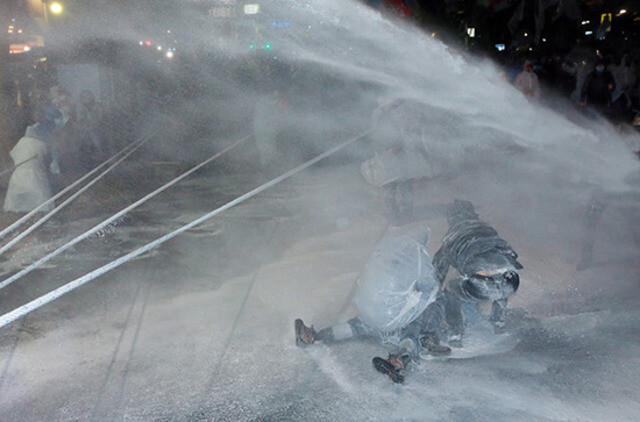 Farmer Baek Nam-gi being blasted by a police water cannon during an anti-government rally in central Seoul