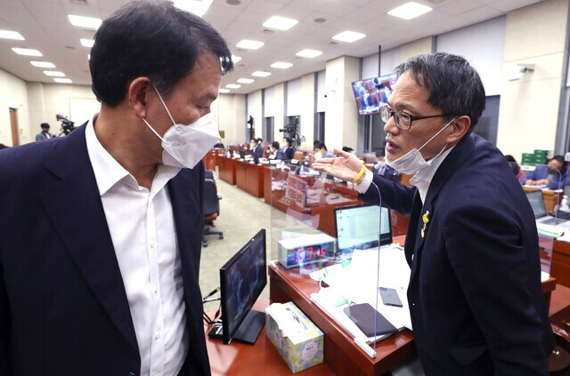 Democratic Party lawmaker Park Ju-min (right), acting chairman of the National Assembly Legislation and Judiciary Committee, and People Power Party lawmaker Yoon Han-hong have a sideline conversation during the plenary session of the committee on Tuesday. (Yonhap News)