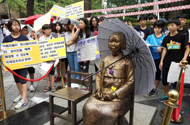 The comfort women statue outside the Japanese embassy in Seoul’s Jongno district sports an umbrella
