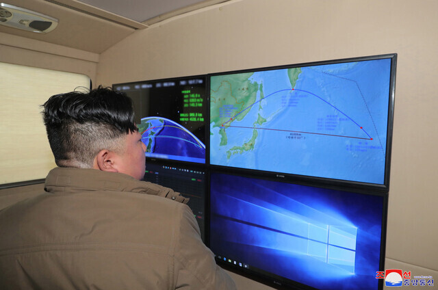 North Korean leader Kim Jong-un looks at monitors showing the flight trajectory of an IRBM launched by the North on Oct. 4 that passed through Japanese airspace and landed in the Pacific, in this photo released by state media. (KCNA/Yonhap)