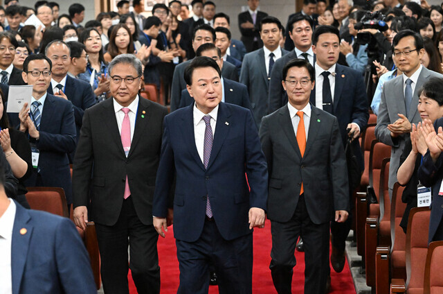 President Yoon Suk-yeol enters an event celebrating the 60th anniversary of the Korean National Diplomatic Academy flanked by Foreign Minister Park Jin (left) and the academy’s chancellor, Park Cheol-hee. (presidential office pool photo)