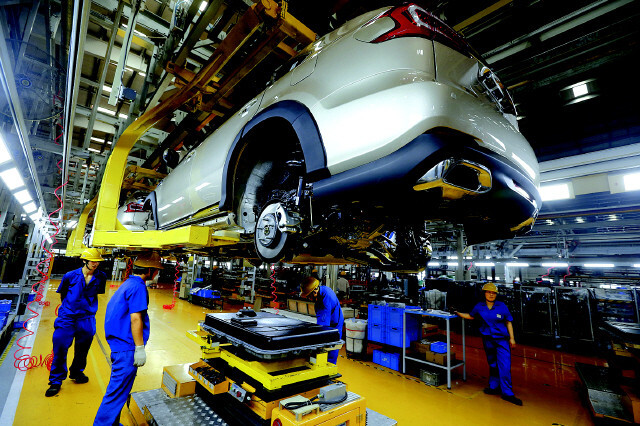 A battery is being fixed to an electric car at a BYD factory in Shenzhen, China. (Yonhap News)