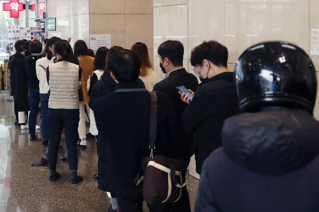 South Koreans stand in line at a pharmacy to buy protective masks on Mar. 3. (Yonhap News)