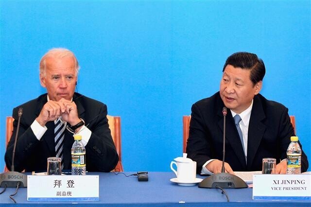 Then-US Vice President Joe Biden and Chinese President Xi Jinping sit next to each other at an event. (AP/Yonhap News)