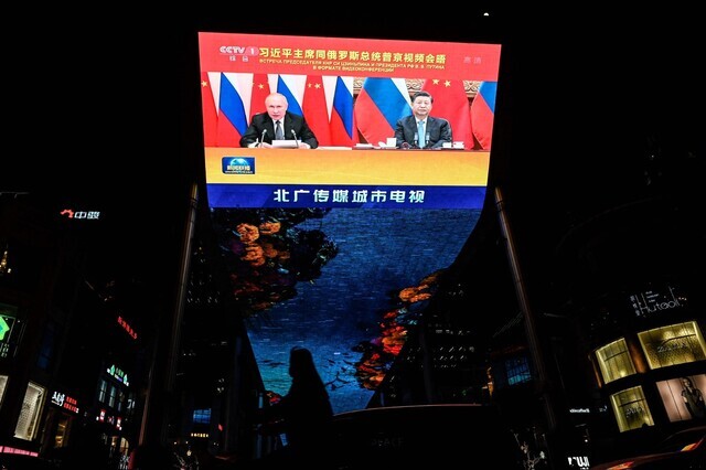 A monitor at an urban shopping center in Beijing shows the virtual summit between Russian President Vladimir Putin and Chinese leader Xi Jinping on Wednesday. (AFP/Yonhap News)
