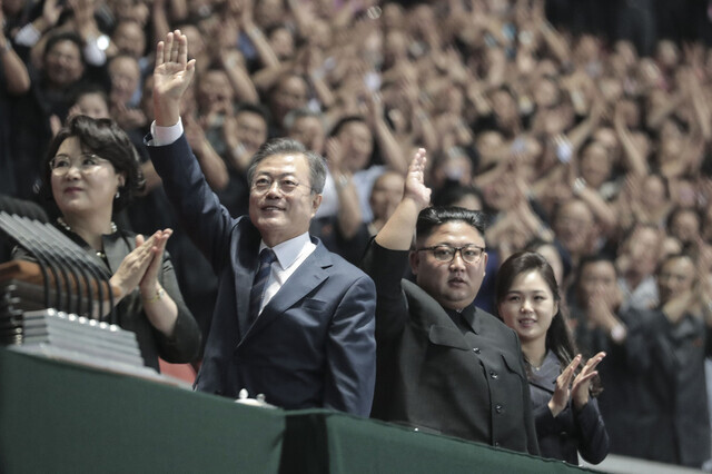 South Korean President Moon Jae-in and North Korean leader Kim Jong-un wave to the crowd at a Rungrado 1st of May Stadium in Pyongyang on Sept. 19, 2018. (Pyongyang pool photo) 