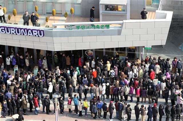 부산저축은행과 대전저축은행이 금융당국으로부터 6개월 영업정지를 당한 2011년 2월18일 부산2저축은행 해운대지점 예금자들이 예금인출을 위한 번호표를 받으려고 줄을 서서 기다리고 있다. 연합뉴스