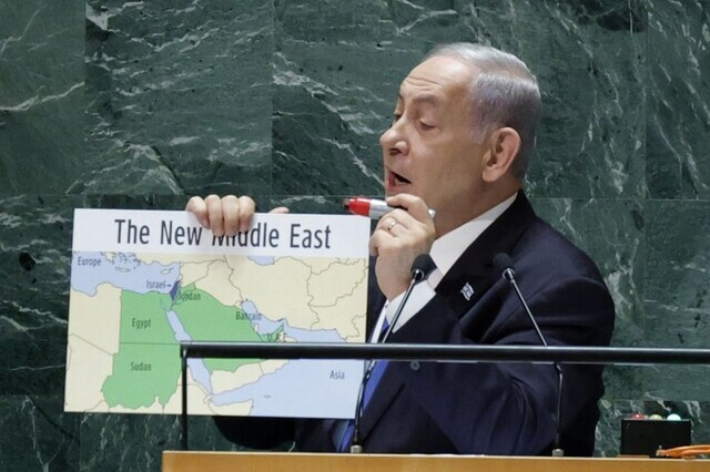 Prime Minister Benjamin Netanyahu holds up a map reading “The New Middle East” that does not depict Palestine while speaking before the UN General Assembly on Sept. 22. (UPI/Yonhap)