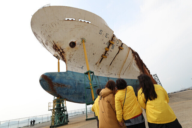 People gaze at the body of the MV Sewol ferry after it was recovered on March 23, 2017, and brought to a port in Mokpo. (Kim Bong-gyu/The Hankyoreh)