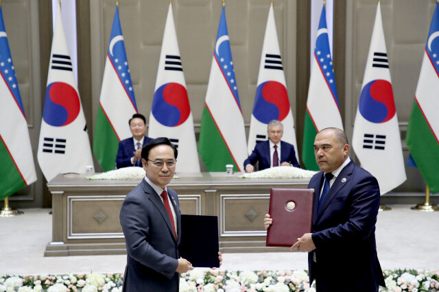 우즈베키스탄 대통령궁에서 2024년 6월14일(현지시각) 열린 양해각서(MOU) 서명식에서 이용배 현대로템 사장(왼쪽)과 주파르 나르줄라예프 우즈베키스탄 철도공사 사장이 ‘우즈베키스탄 철도공사 고속철 6편성 공급계약’에 서명한 뒤 기념사진을 찍고 있다. 대통령실사진기자단