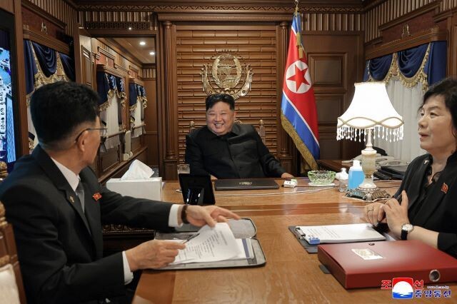 김정은 조선노동당 총비서 겸 국무위원장이 중국 베이징으로 가는 전용열차 안 집무실에서 당·정의 외교 책임자인 김성남 노동당 중앙위 국제부장(왼쪽), 최선희 외무상(오른쪽)과 웃는 얼굴로 회의를 하고 있다. 조선중앙통신 연합뉴스