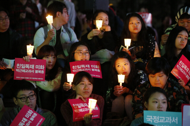 Youths and citizens hold a candlelight vigil to oppose the government’s move for state-issued history textbooks