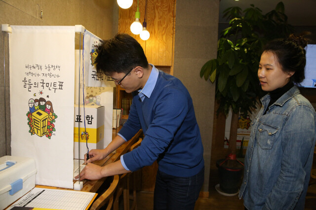 한겨레신문사에 마련된 ‘을들의 국민투표’ 기표소에서 직원들이 박근혜 정부 노동정책을 평가하는 투표를 진행하고 있다. 류우종 기자