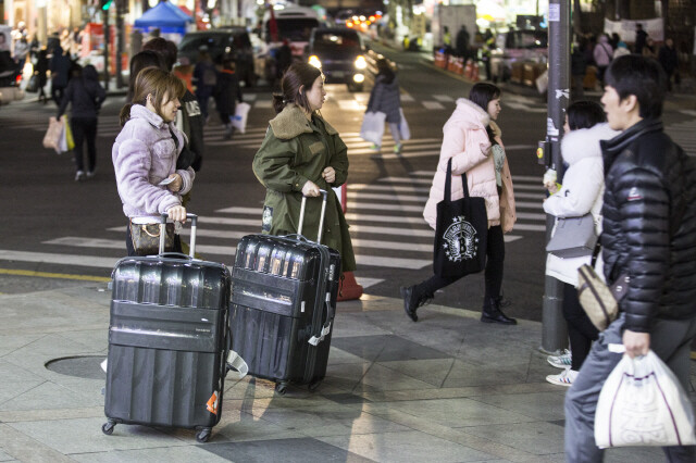 Chinese traders carry goods in suitcases after shopping on the night of Feb. 24 at Dongdaemun Market in Seoul. At the market they’re called “hand-carry sellers.” (by Kim Seong-gwang