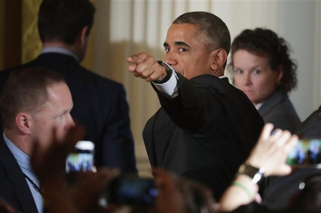 US President Barack Obama points to the audience after his speech at a reception for Women’s History Month in the East Room of the White House in Washington DC