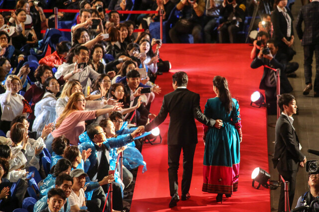 South Korean actor Song Kang-ho greets fans while walking the red carpet before hosting the opening ceremony of the Busan International Film Festival with Afghan actor Marina Golbahari