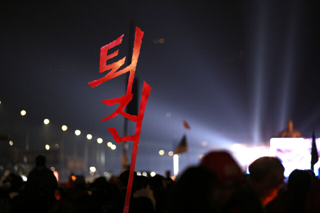 11월26일 서울 광화문광장에서 열린 촛불집회 때 한 참가자가 ‘퇴진’ 구호를 들었다. ‘광장의 정치’는 ‘의회의 정치’를 압박할 수 있을까. 류우종 기자